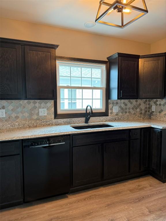 305 E 5th St, Vinton, IA 52349 - kitchen featuring a sink, black dishwasher, backsplash, light wood-style flooring, and light countertops