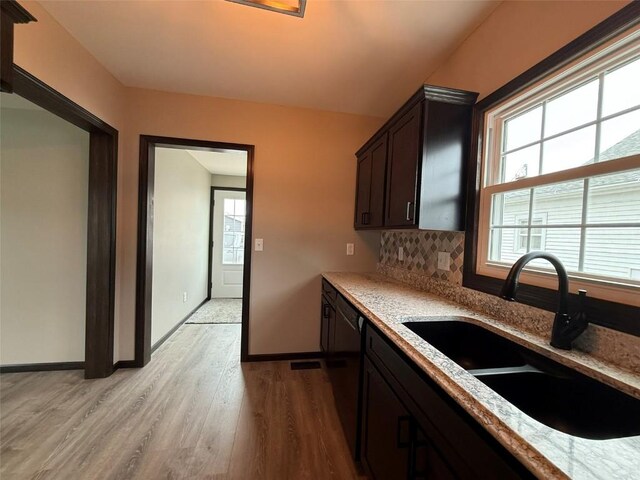 305 E 5th St, Vinton, IA 52349 - kitchen featuring light wood finished floors, a sink, dark brown cabinets, and plenty of natural light