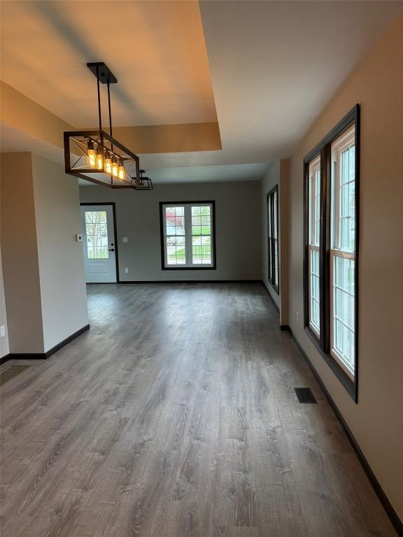305 E 5th St, Vinton, IA 52349 - unfurnished dining area featuring baseboards, visible vents, and wood finished floors