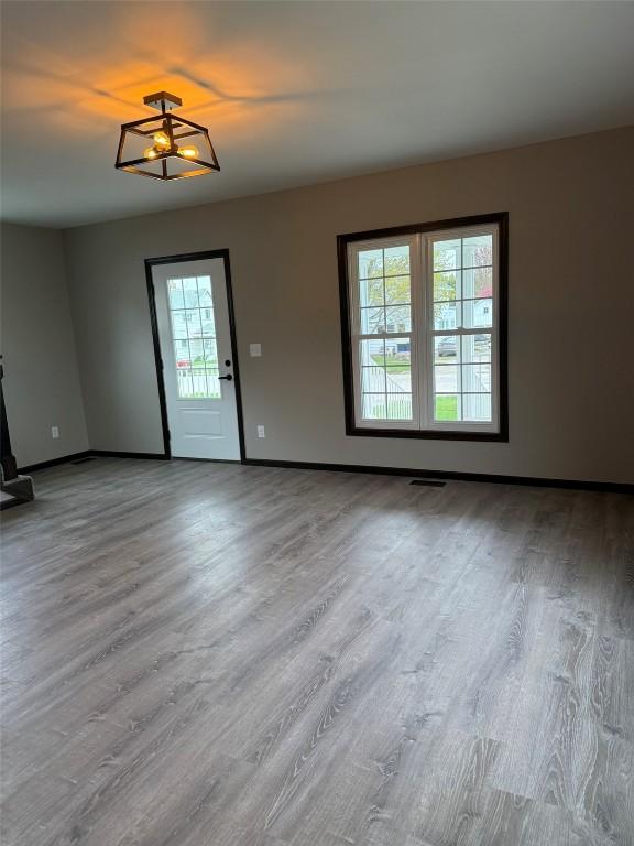 305 E 5th St, Vinton, IA 52349 - interior space featuring baseboards, visible vents, wood finished floors, and a healthy amount of sunlight