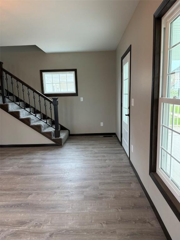 305 E 5th St, Vinton, IA 52349 - entrance foyer with wood finished floors, plenty of natural light, baseboards, and stairs