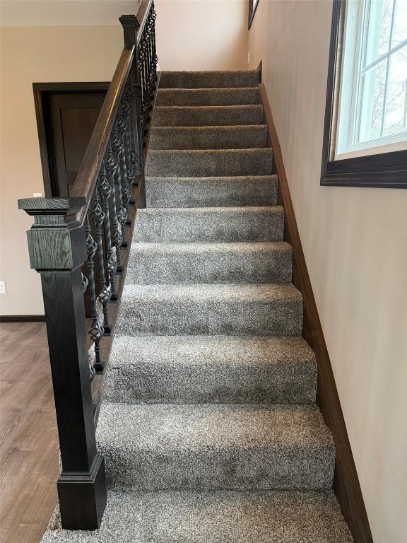 305 E 5th St, Vinton, IA 52349 - stairs with baseboards and wood finished floors