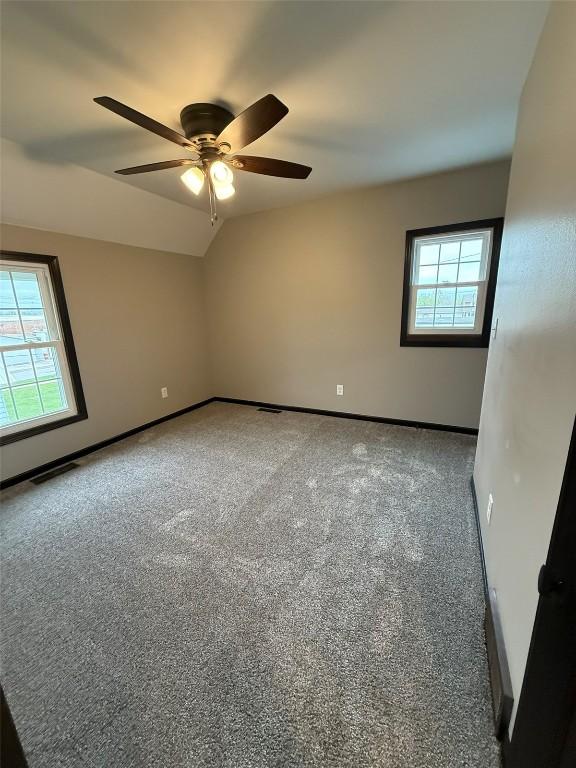 305 E 5th St, Vinton, IA 52349 - empty room with ceiling fan, plenty of natural light, baseboards, and carpet floors