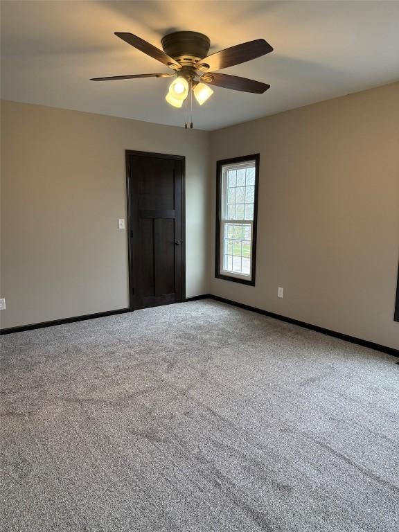305 E 5th St, Vinton, IA 52349 - spare room featuring carpet, ceiling fan, and baseboards