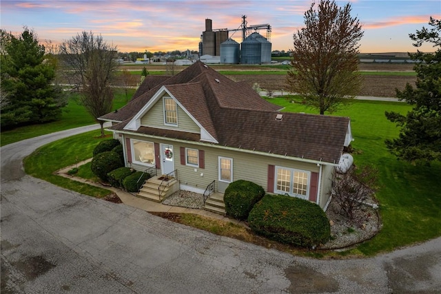 view of front of house with a front lawn and roof with shingles