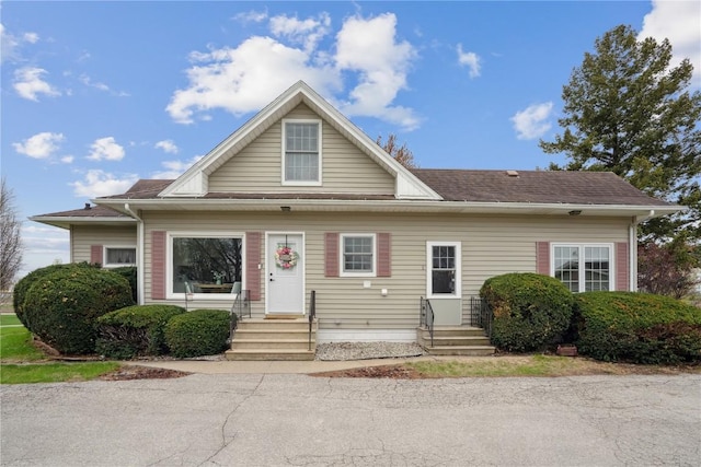 bungalow-style house with a shingled roof and entry steps
