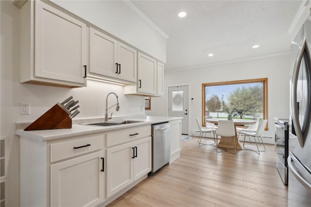 kitchen with stainless steel appliances, recessed lighting, ornamental molding, and a sink