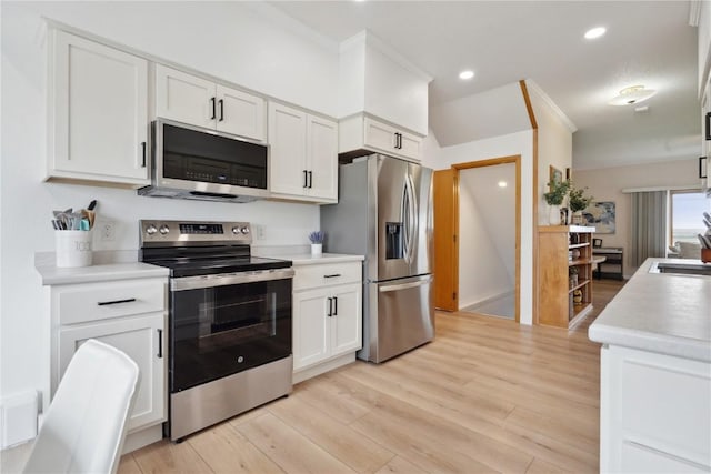kitchen with light wood-style flooring, white cabinetry, light countertops, ornamental molding, and appliances with stainless steel finishes