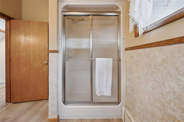 bathroom with wood finished floors and an enclosed shower
