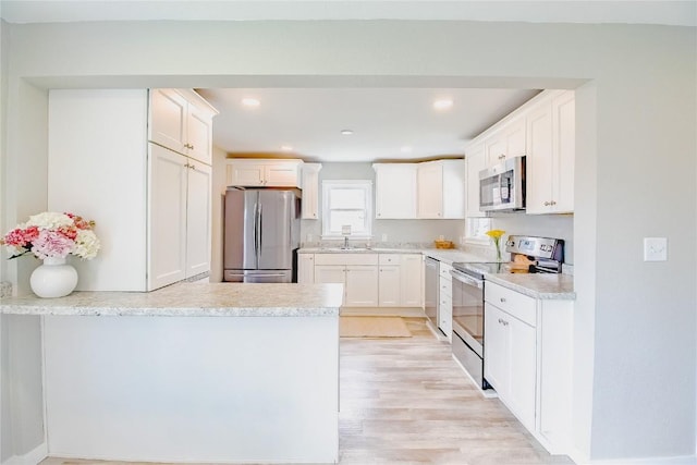 2095 3rd Ave, Marion, IA 52302 - kitchen with appliances with stainless steel finishes, a peninsula, white cabinetry, light countertops, and recessed lighting