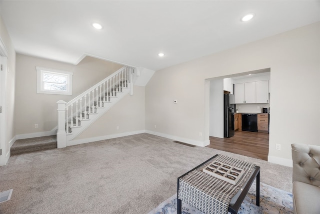 317 16th St NE, Cedar Rapids, IA 52402 - unfurnished living room with stairs, light carpet, baseboards, and recessed lighting