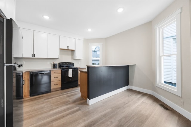 317 16th St NE, Cedar Rapids, IA 52402 - kitchen featuring black appliances, light wood finished floors, white cabinets, light countertops, and baseboards