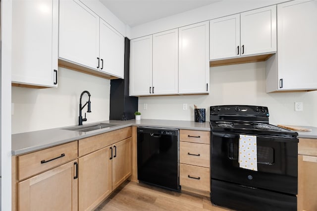 317 16th St NE, Cedar Rapids, IA 52402 - kitchen with black appliances, a sink, light wood-type flooring, and light countertops