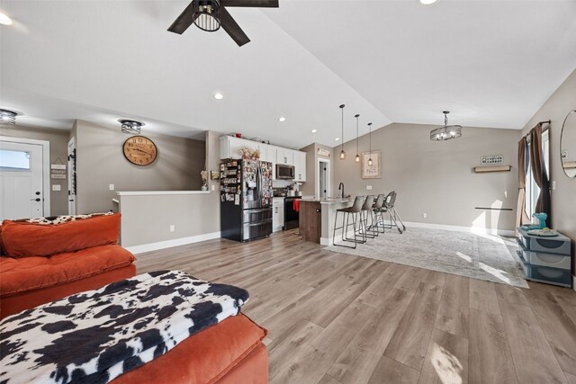 5116 Ruhd St SW, Cedar Rapids, IA 52404 - living room featuring lofted ceiling, light wood finished floors, a ceiling fan, and recessed lighting