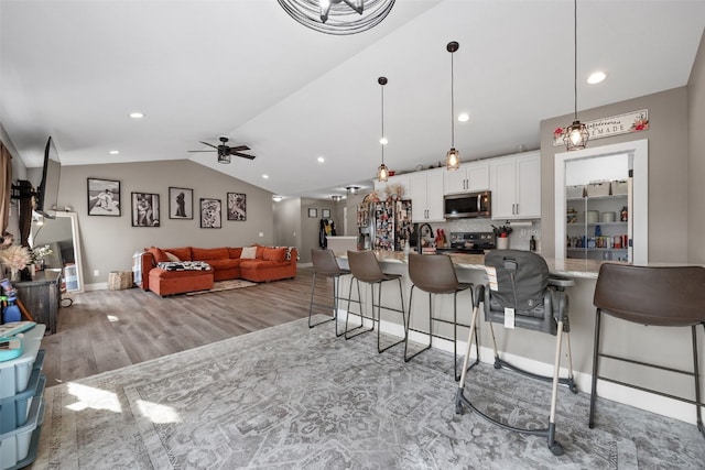 5116 Ruhd St SW, Cedar Rapids, IA 52404 - living room with a ceiling fan, vaulted ceiling, light wood-style flooring, and recessed lighting