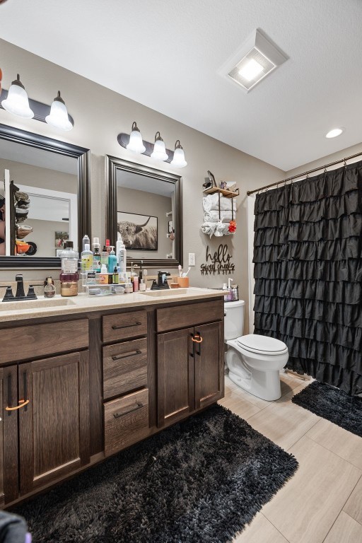 5116 Ruhd St SW, Cedar Rapids, IA 52404 - bathroom with double vanity, curtained shower, toilet, and a sink