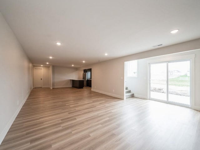 5497 Silver Ridge Rd, Marion, IA 52302 - unfurnished living room with stairway, baseboards, light wood-style floors, and recessed lighting