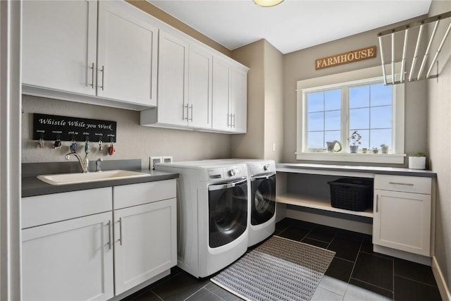 clothes washing area with dark tile patterned floors, a sink, cabinet space, and independent washer and dryer