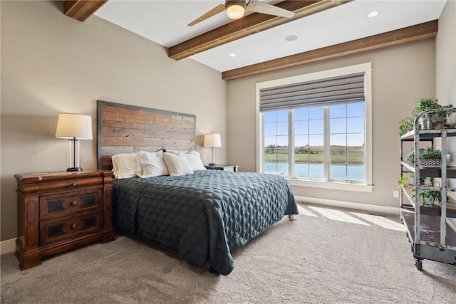 bedroom with beamed ceiling, ceiling fan, a water view, and carpet