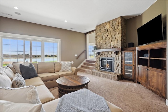 carpeted living area featuring visible vents and a fireplace