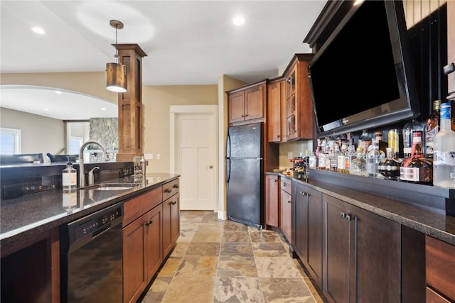 kitchen with a sink, glass insert cabinets, black appliances, decorative light fixtures, and arched walkways