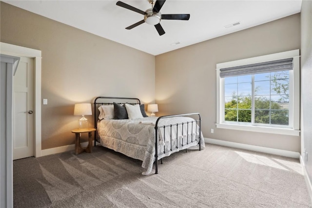 carpeted bedroom featuring baseboards, visible vents, and ceiling fan