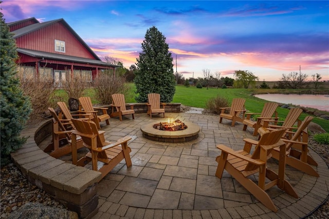 view of patio featuring an outdoor fire pit and a water view