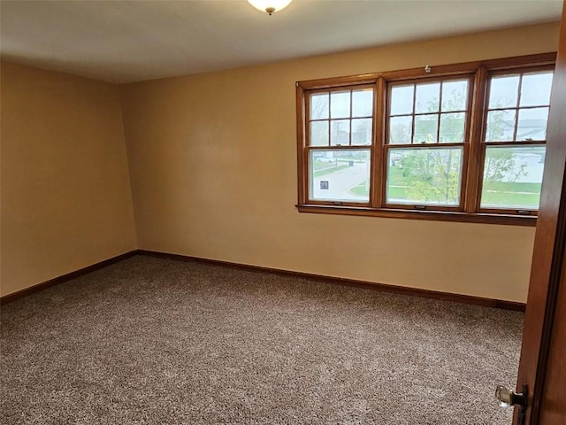 carpeted spare room featuring baseboards