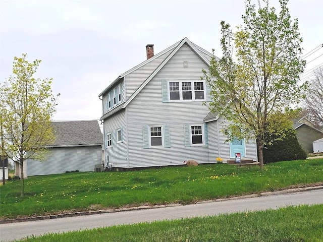 view of side of property with a lawn, a chimney, and central AC unit