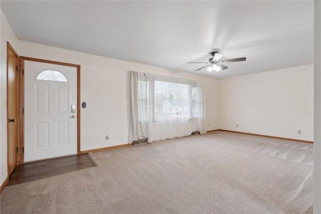 carpeted foyer with a healthy amount of sunlight, baseboards, and ceiling fan