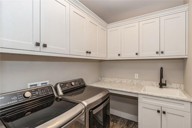 laundry room featuring a sink, cabinet space, dark wood-style flooring, and washing machine and dryer