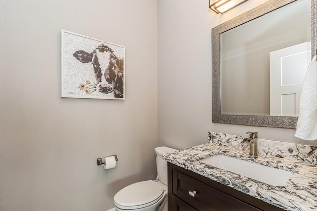 half bathroom featuring vanity and toilet