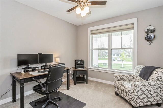 carpeted office space with baseboards and a ceiling fan