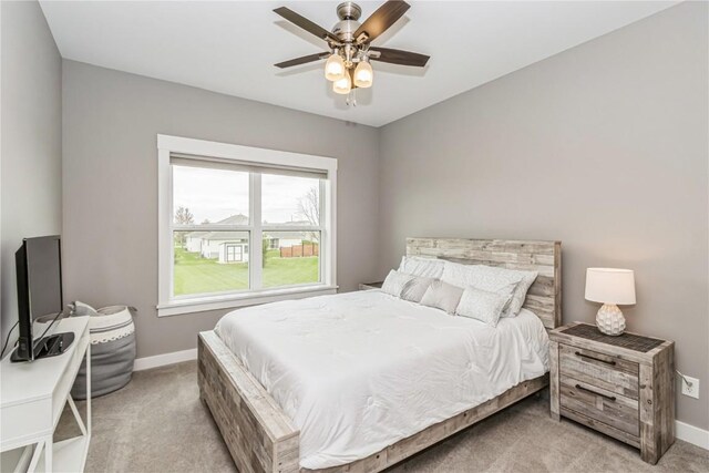 carpeted bedroom featuring baseboards and ceiling fan