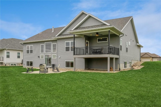 rear view of property featuring a lawn, roof with shingles, and a patio area