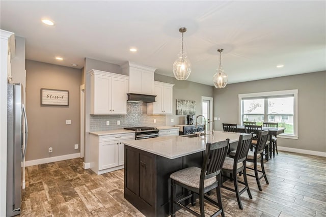 kitchen with light countertops, stainless steel appliances, baseboards, and a sink