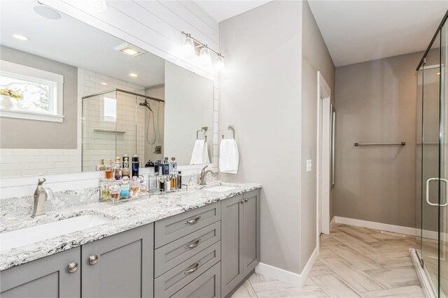 bathroom featuring double vanity, a sink, and a stall shower