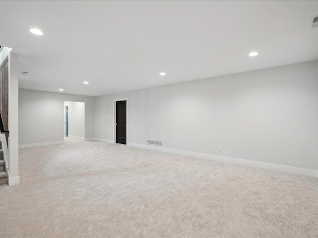 below grade area featuring light colored carpet, recessed lighting, and visible vents