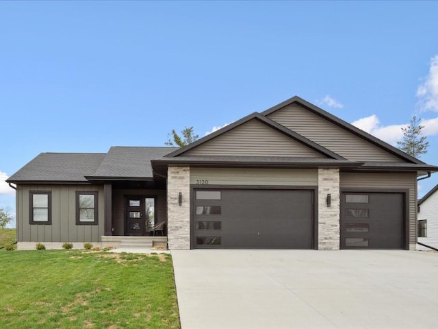 view of front of home with roof with shingles, a garage, board and batten siding, a front yard, and driveway