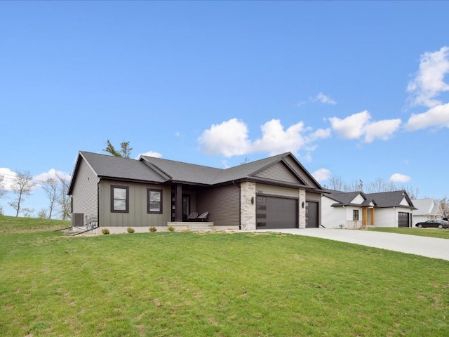view of front of home with a garage, central AC, a front yard, and concrete driveway