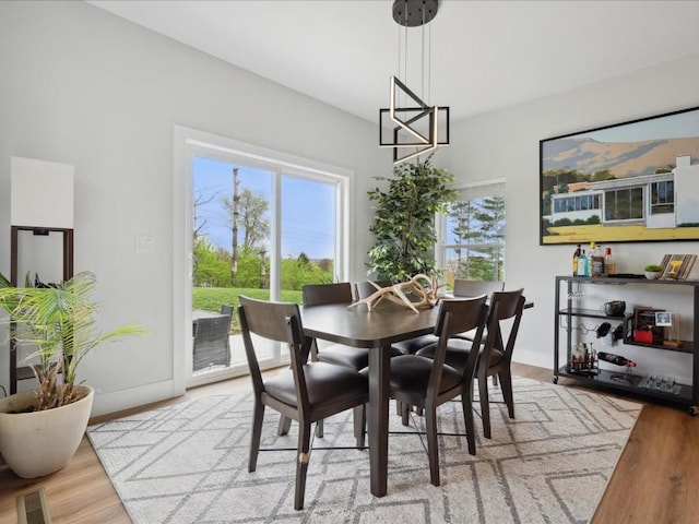 dining area with a chandelier, wood finished floors, and visible vents