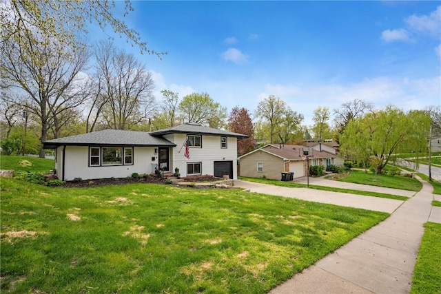 split level home featuring concrete driveway, a front lawn, and a garage