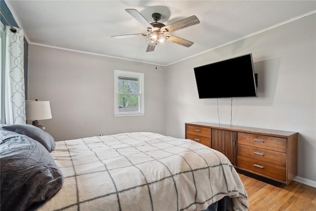 bedroom with baseboards, ornamental molding, light wood-style flooring, and ceiling fan