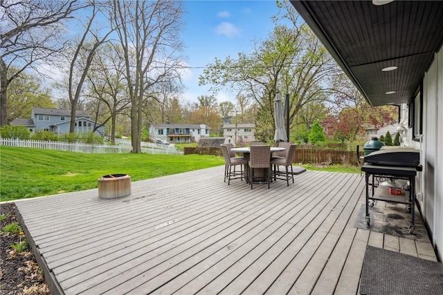 wooden deck with a lawn, grilling area, a fenced backyard, and outdoor dining space