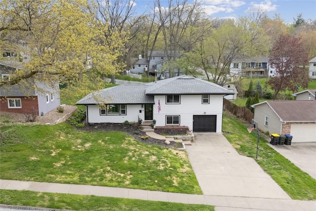 split level home featuring a garage, a front yard, a residential view, and concrete driveway