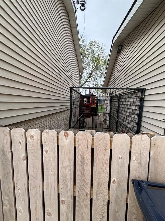 view of side of property featuring fence and a gate