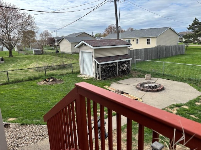 view of yard featuring a storage shed, an outbuilding, a fenced backyard, and an outdoor fire pit