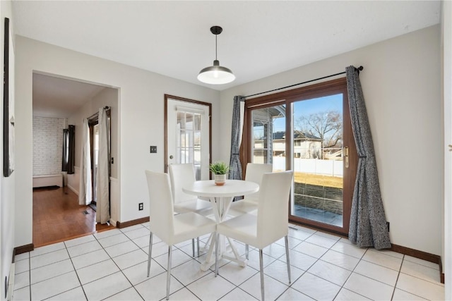 dining room featuring baseboards and light tile patterned flooring