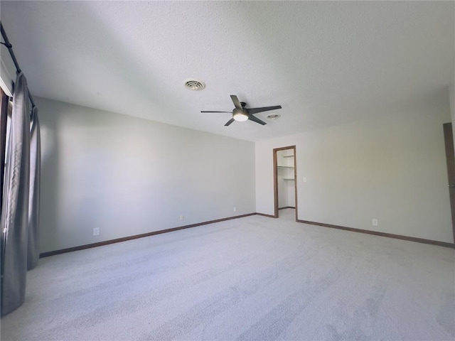unfurnished room featuring visible vents, a ceiling fan, baseboards, and light carpet