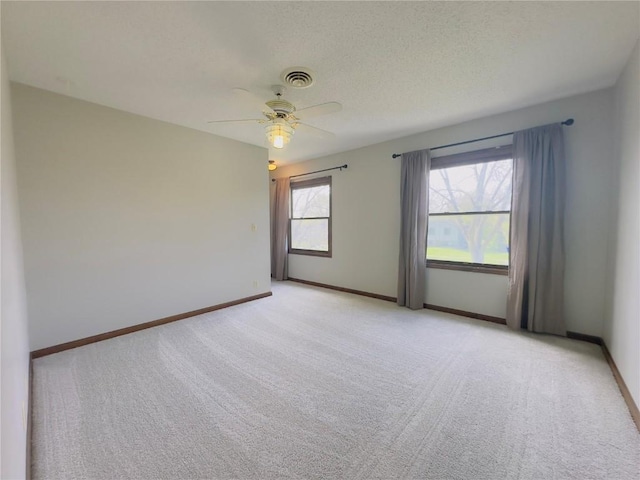 unfurnished room with a ceiling fan, baseboards, light colored carpet, and visible vents
